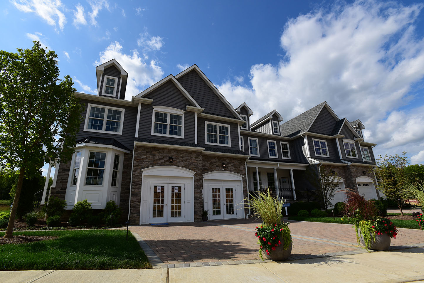 Exterior of Barclay Brook Village with brick paver driveway, manicured grass, and brick front