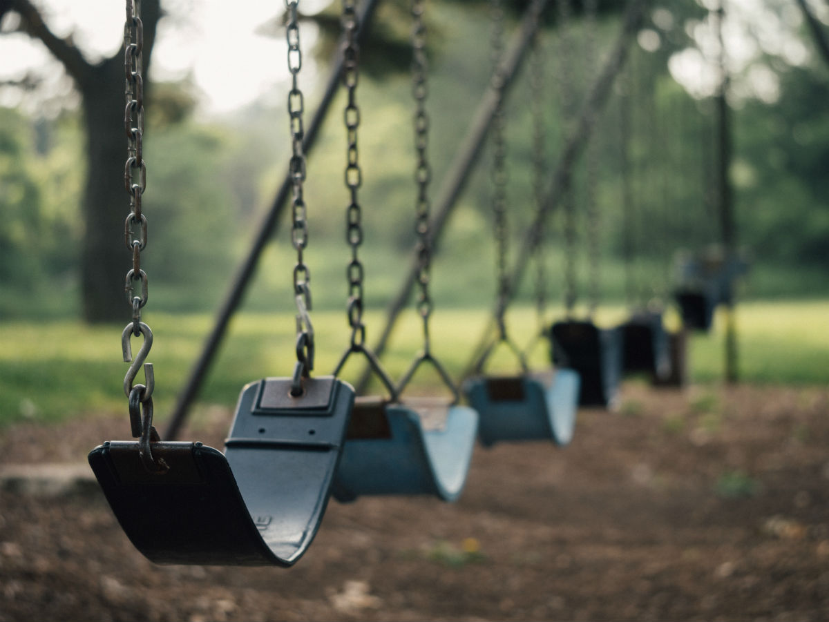 Green swings on an outdoor playground